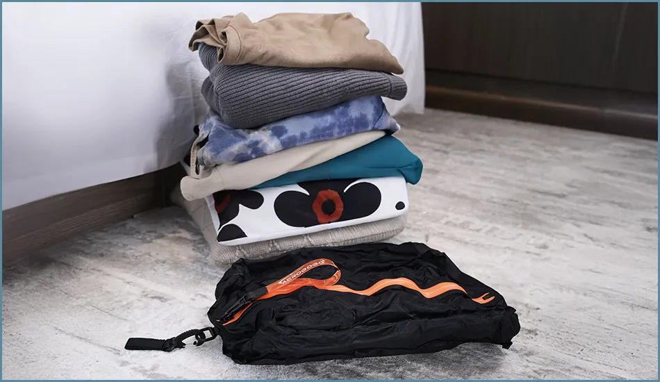 Ułożone rzeczy swetry, bluzki i leżąca torba Aerogogo Travel Vaccum Bag